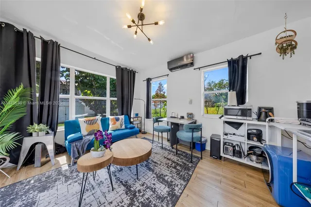 a living room with furniture flat screen tv and a large window