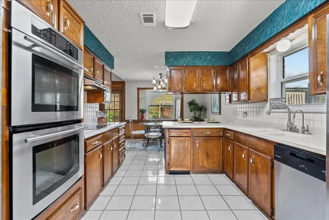 a kitchen with stainless steel appliances granite countertop a sink and cabinets