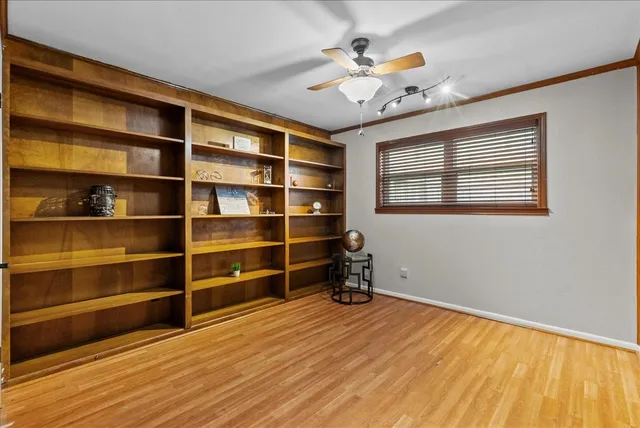 a view of a room with wooden floor and a ceiling fan