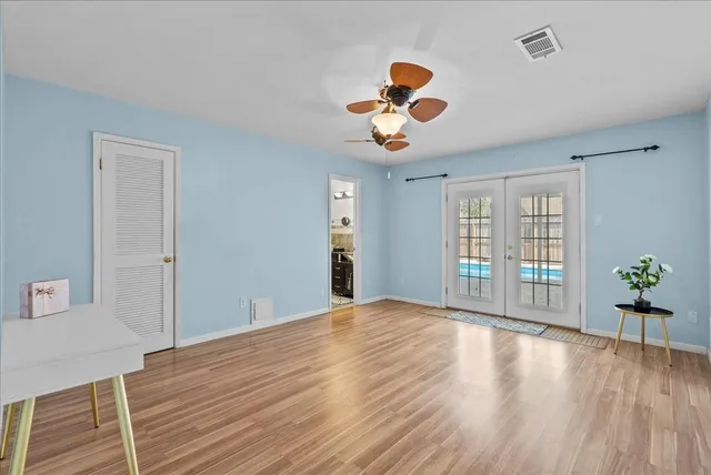 a view of room with wooden floor and ceiling fan