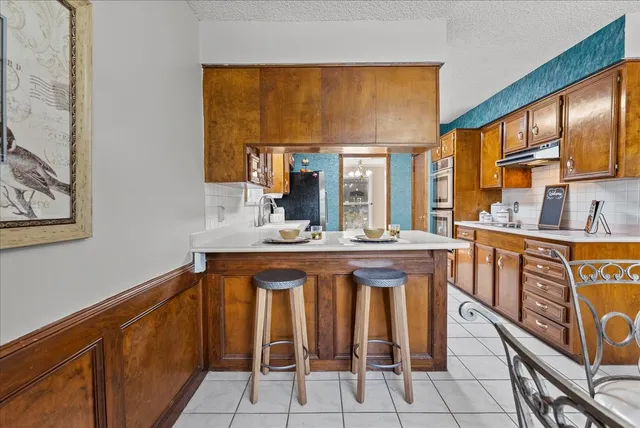 a kitchen with granite countertop lots of white cabinets a sink and dishwasher
