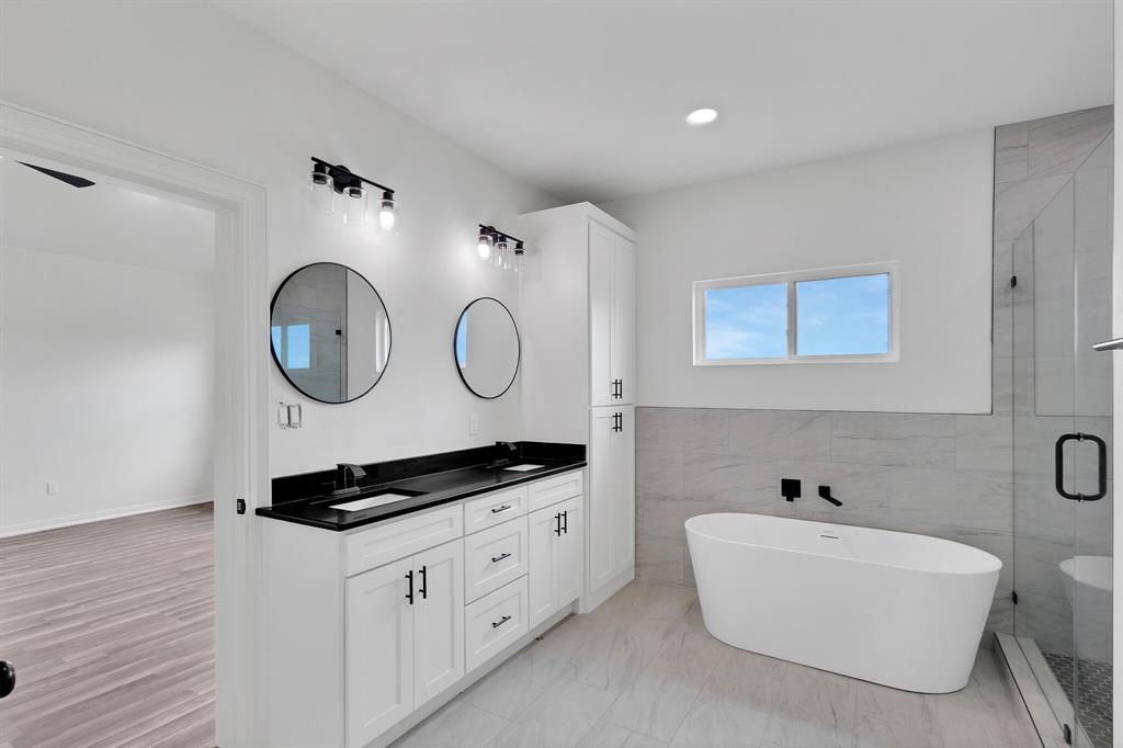 901 Old Maypearl Road Waxahachie, TX 75167 - Photo 12 of 17 Bathroom featuring a double vanity with black countertops, round mirrors, and overhead lighting