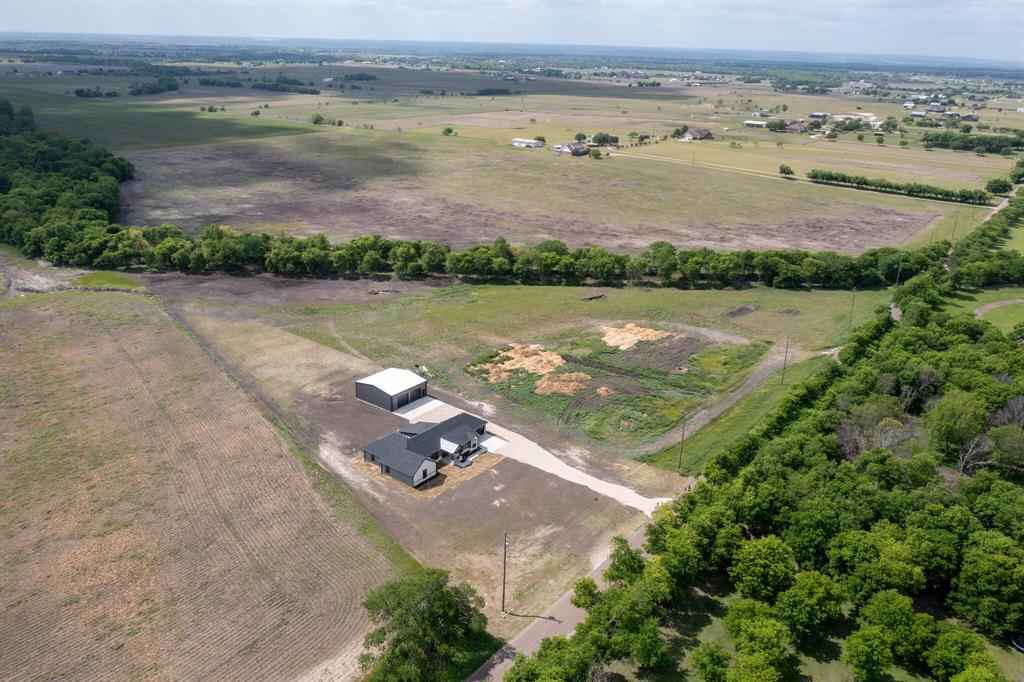 901 Old Maypearl Road Waxahachie, TX 75167 - Photo 15 of 17 The property includes a single-story residence with a dark gray roof and a detached building with a light-colored roof