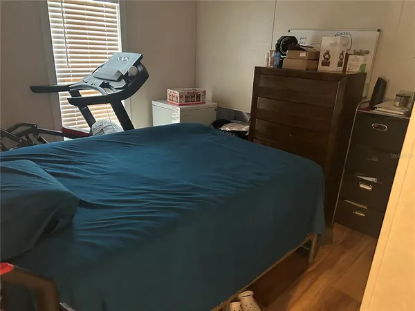 a bedroom with a bed and wooden floor