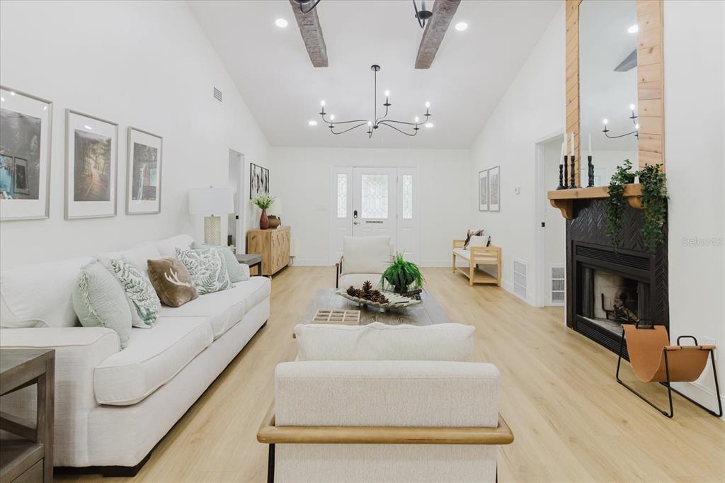 8304 Revels Road Riverview, FL 33569 - Photo 13 of 99 a living room with furniture a fireplace and a chandelier