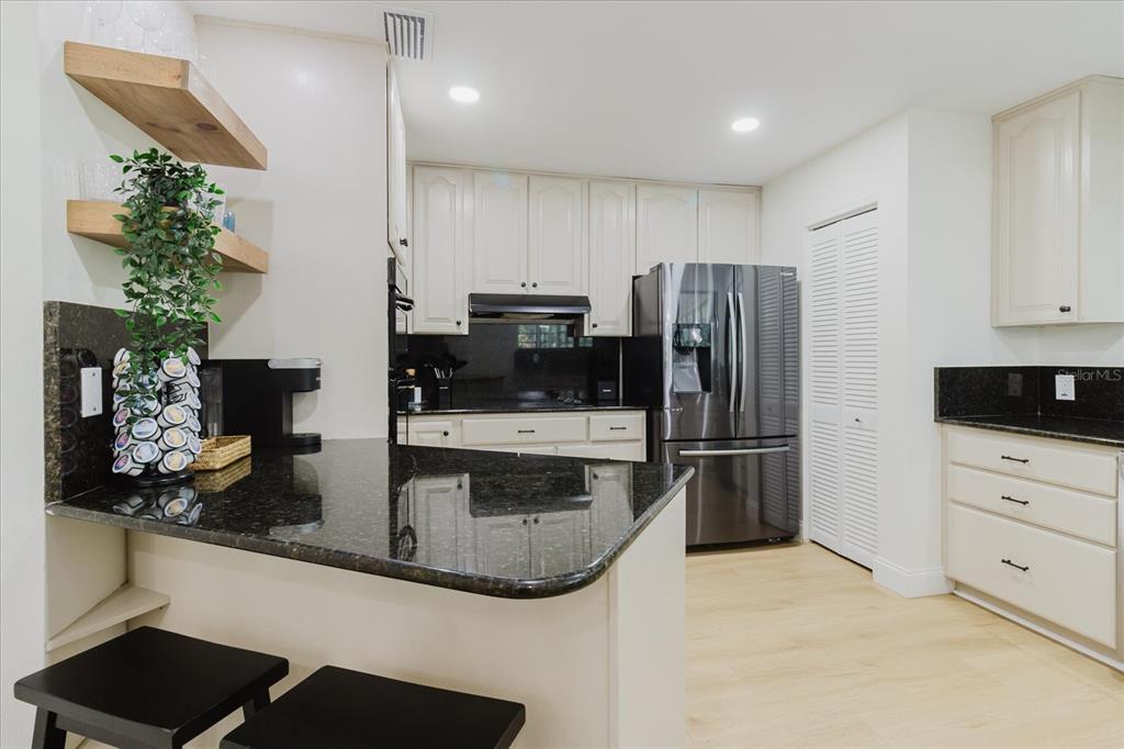 8304 Revels Road Riverview, FL 33569 - Photo 16 of 99 a kitchen with stainless steel appliances kitchen island granite countertop a refrigerator and a stove top oven