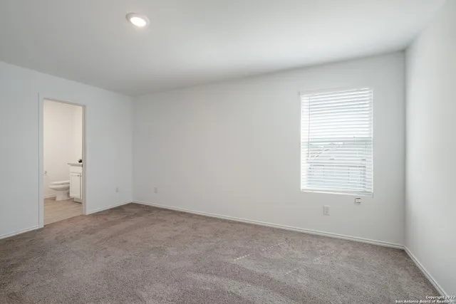 a bathroom with a granite countertop sink a toilet and a mirror