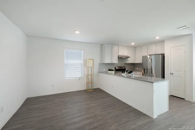 a kitchen with stainless steel appliances granite countertop a sink refrigerator and microwave