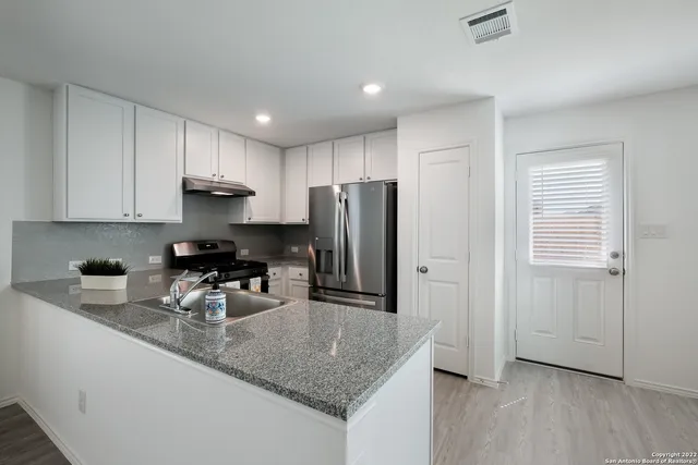 a kitchen with a sink stove and refrigerator