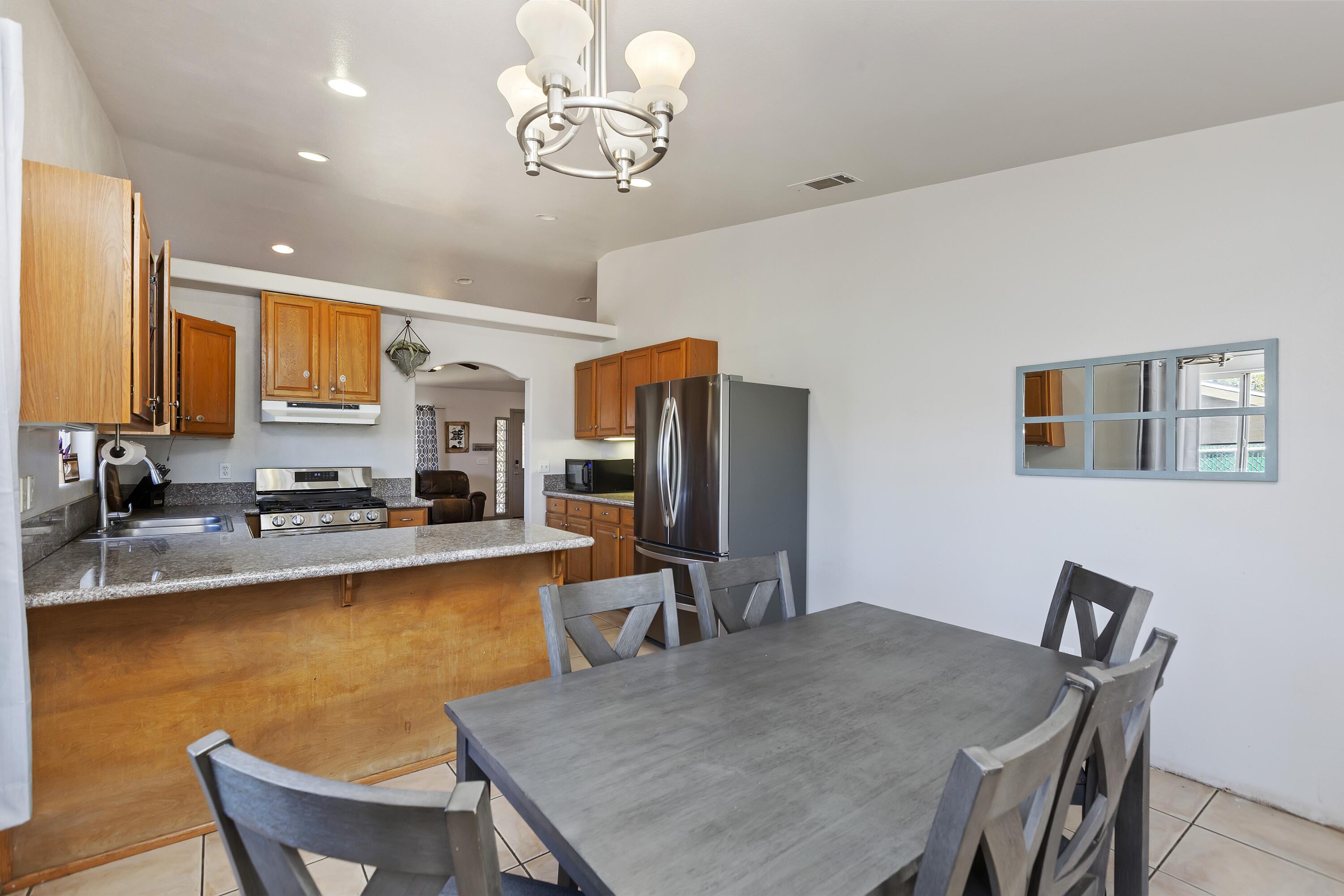 7482 Apache Trail Yucca Valley, CA 92284 - Photo 12 of 38 a view of a dining room with furniture a kitchen and chandelier