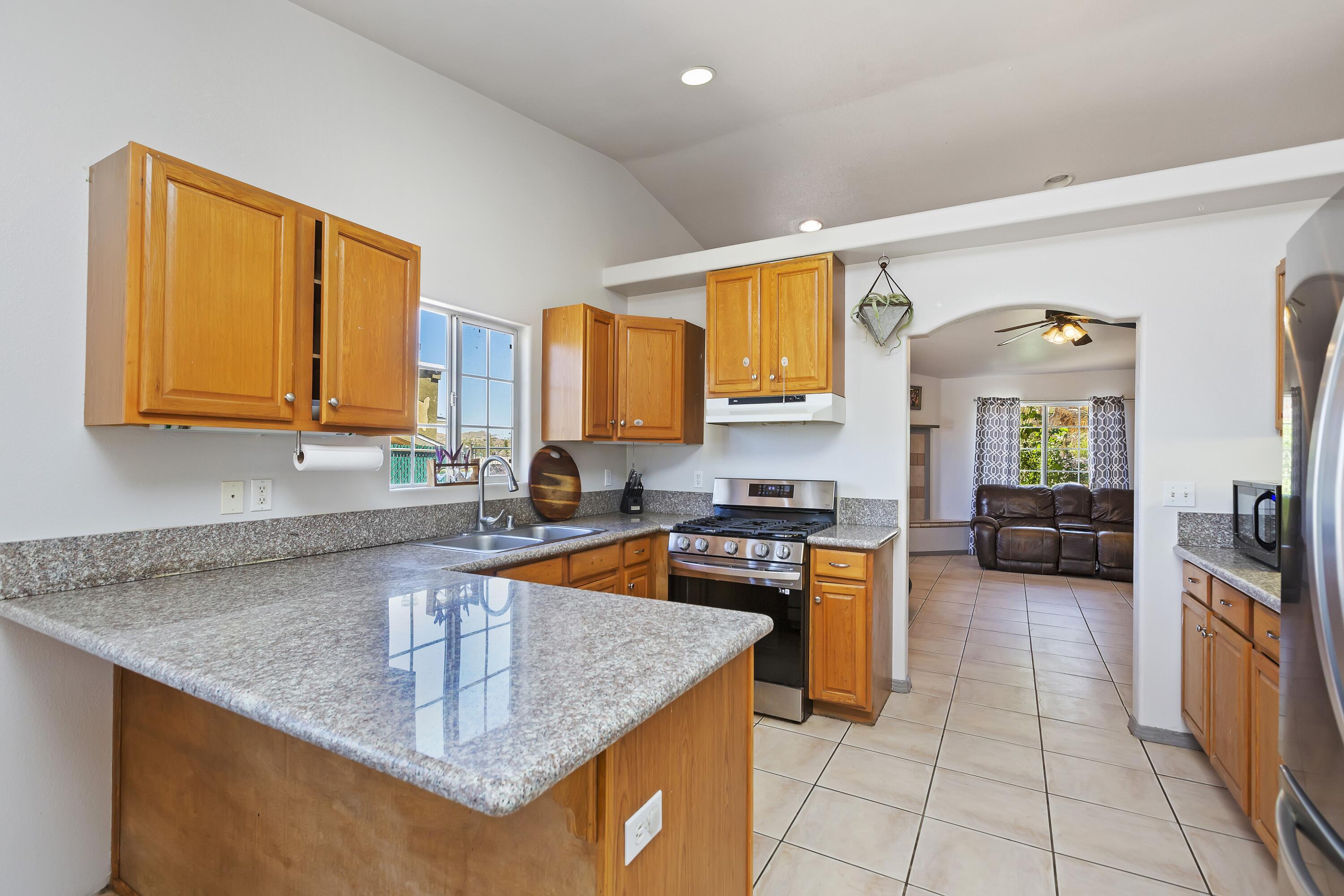 7482 Apache Trail Yucca Valley, CA 92284 - Photo 13 of 38 a kitchen with stainless steel appliances granite countertop a sink stove and cabinets