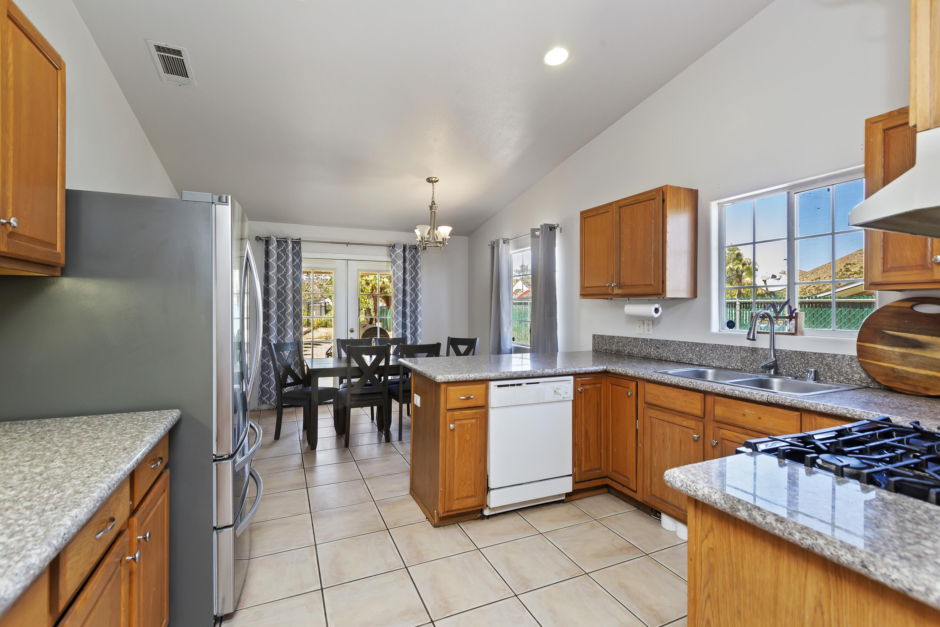 7482 Apache Trail Yucca Valley, CA 92284 - Photo 15 of 38 a kitchen with stainless steel appliances granite countertop sink stove and granite counter top