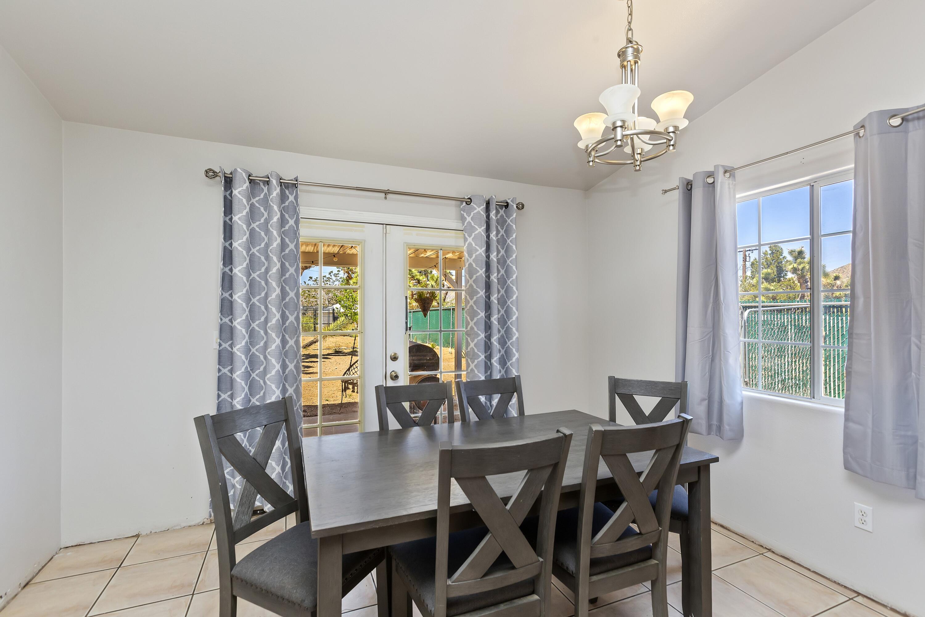 7482 Apache Trail Yucca Valley, CA 92284 - Photo 17 of 38 a view of a dining room with furniture window and outside view