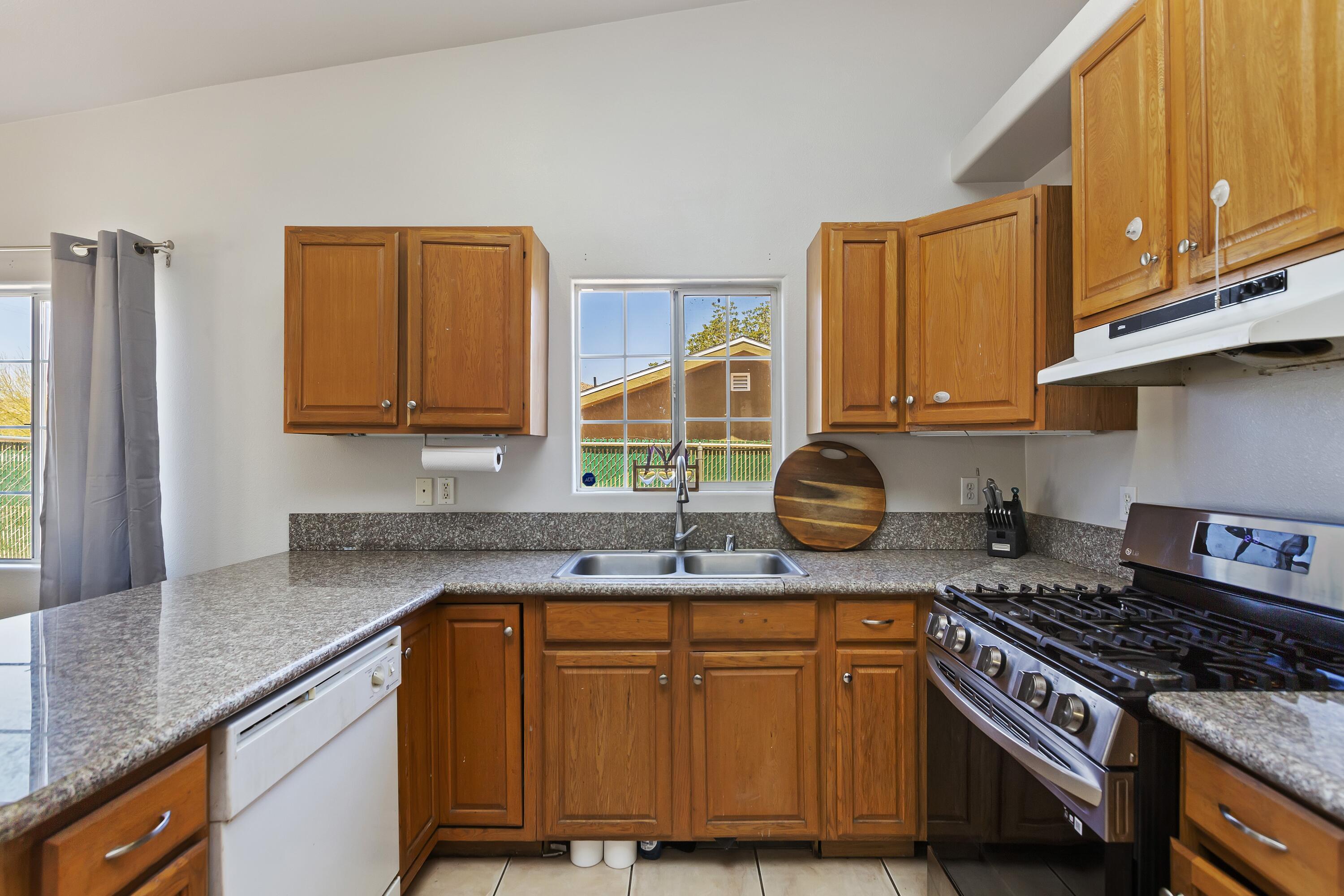 7482 Apache Trail Yucca Valley, CA 92284 - Photo 18 of 38 a kitchen with stainless steel appliances granite countertop a stove a sink and a microwave