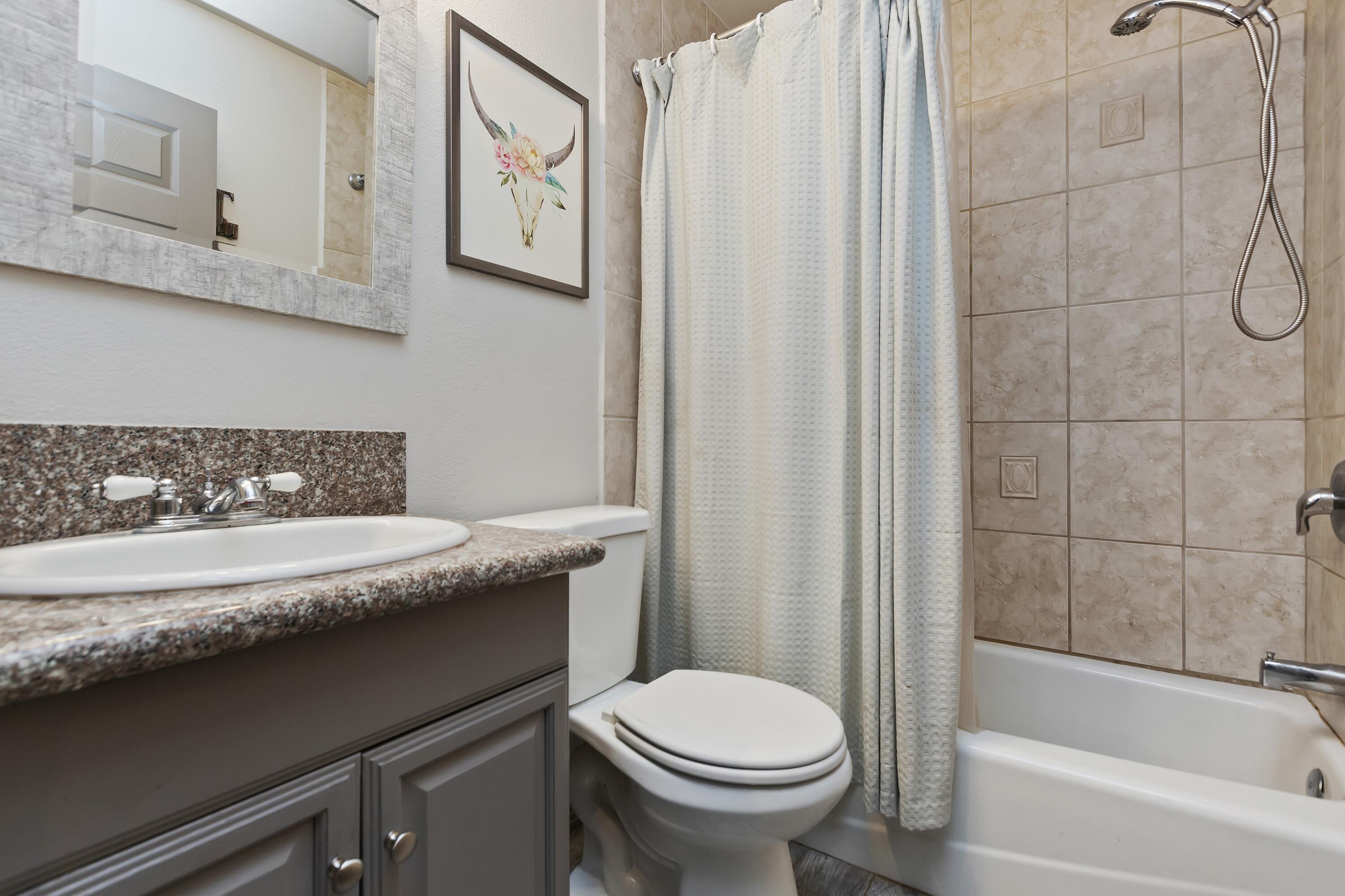 7482 Apache Trail Yucca Valley, CA 92284 - Photo 22 of 38 a bathroom with a granite countertop sink a toilet and bathtub