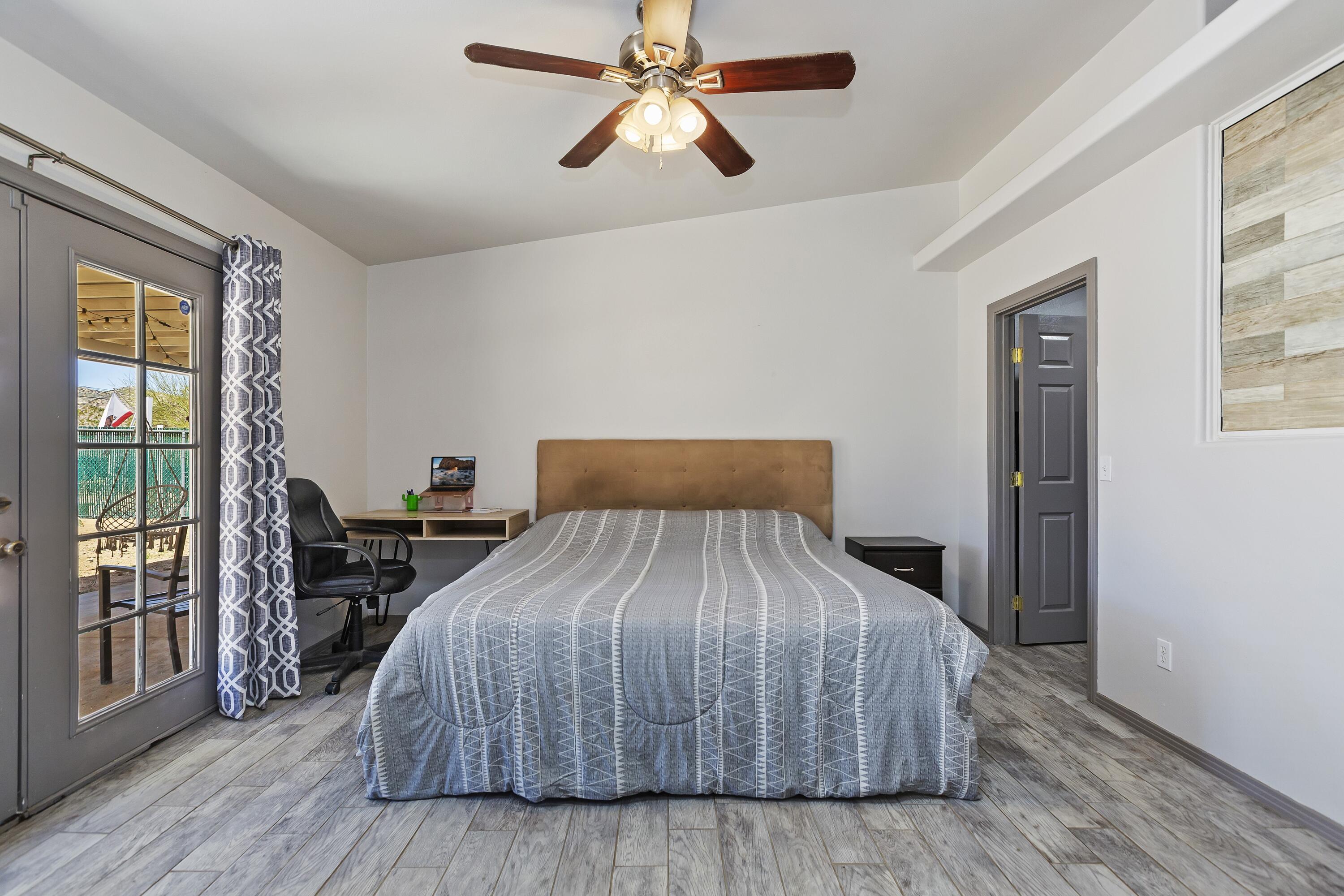 7482 Apache Trail Yucca Valley, CA 92284 - Photo 26 of 38 a bedroom with a bed and wooden floor