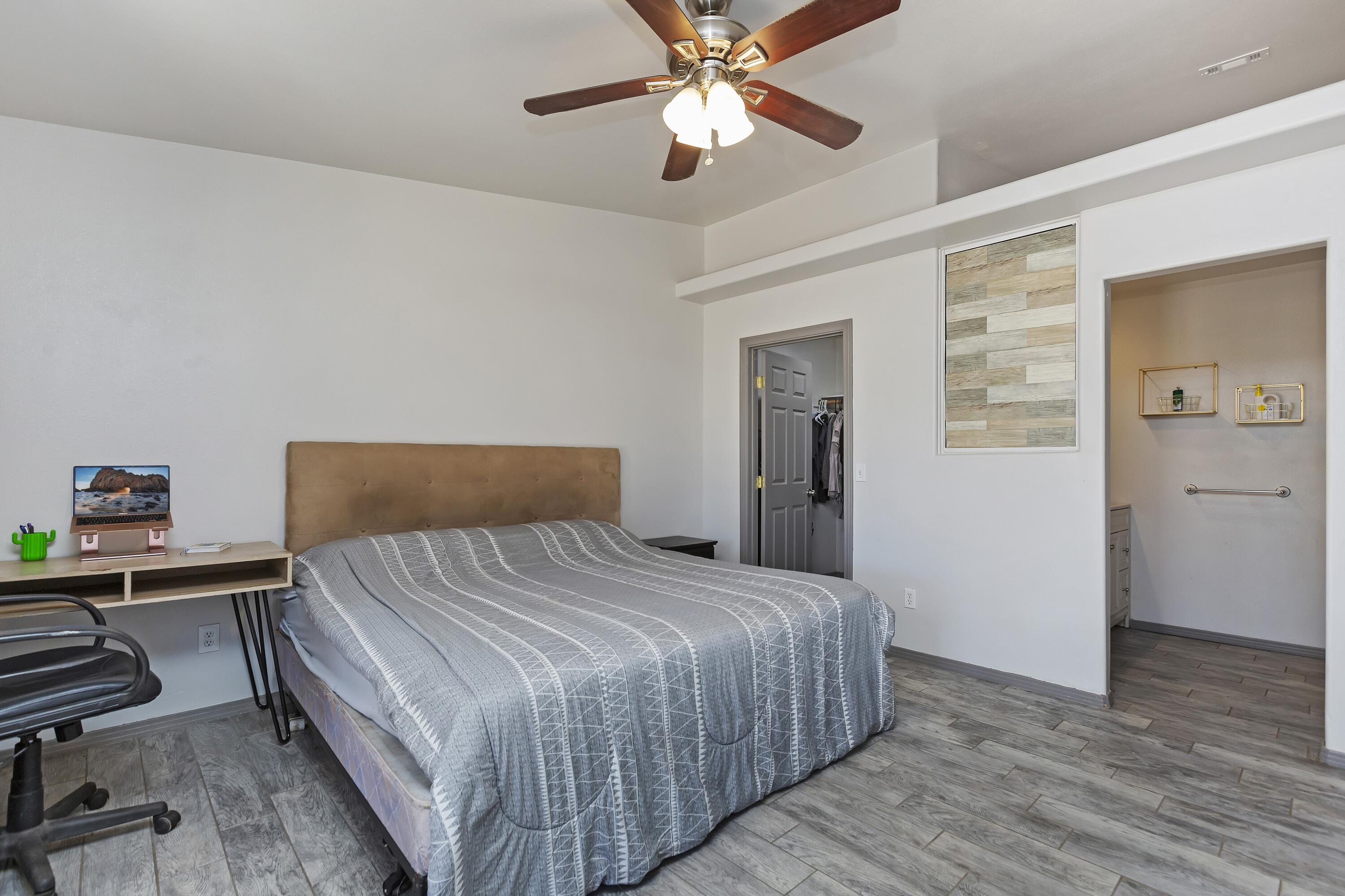 7482 Apache Trail Yucca Valley, CA 92284 - Photo 27 of 38 a bedroom with a bed and a chandelier