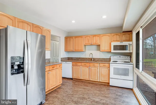 a kitchen with stainless steel appliances granite countertop a refrigerator and a stove top oven