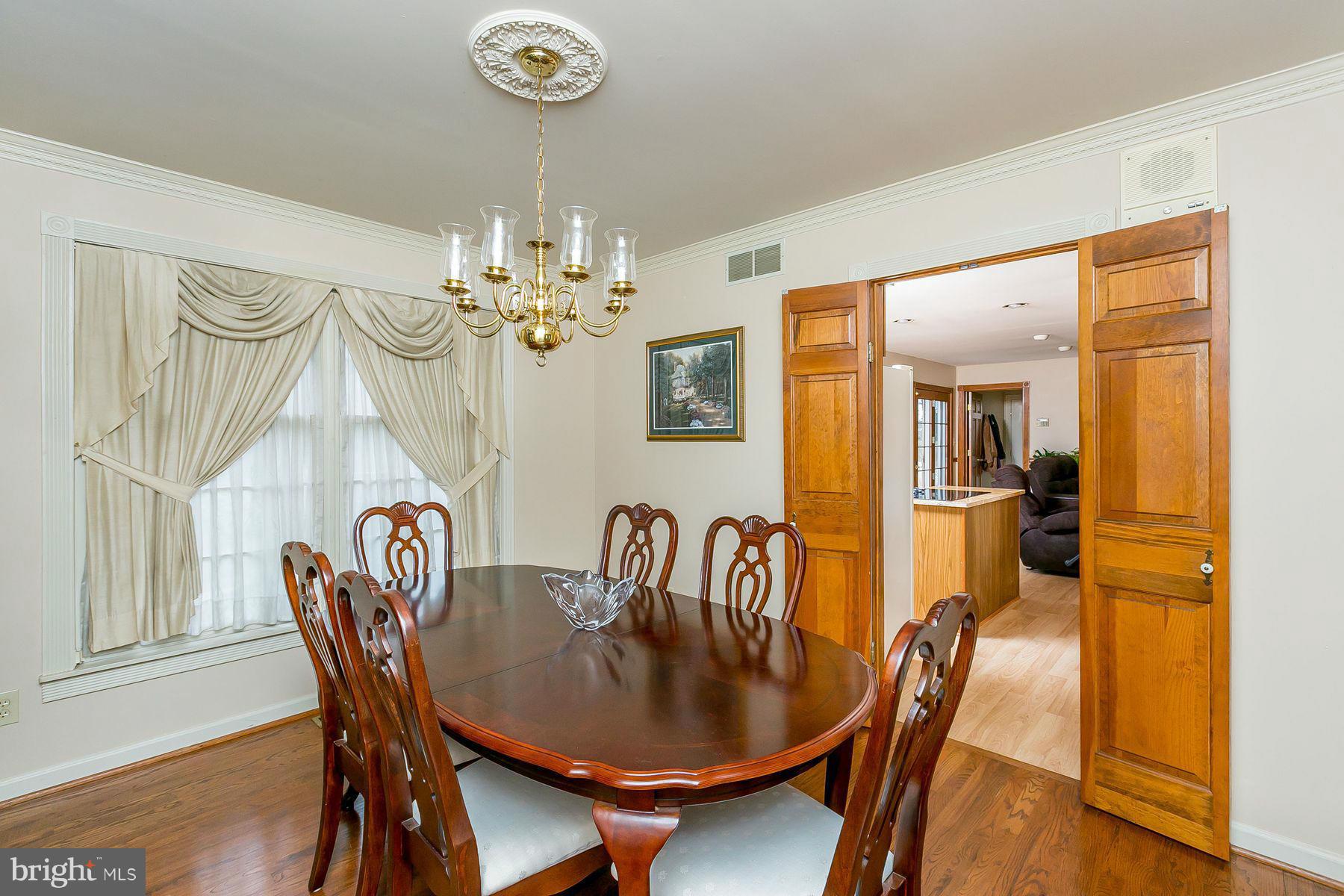 7803 Poplar Grove Road Severn, MD 21144 - Photo 8 of 30 a dining room with furniture a chandelier and wooden floor