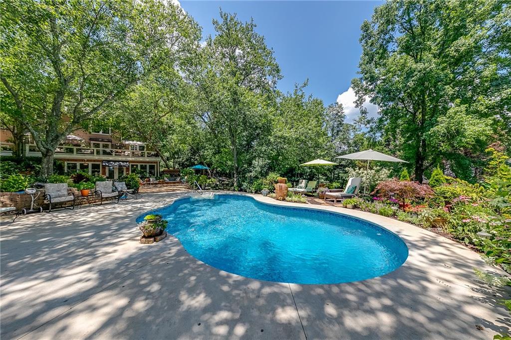 6180 Old Jefferson Road Athens, GA 30607 - Photo 81 of 100 a view of a swimming pool with lawn chairs under an umbrella