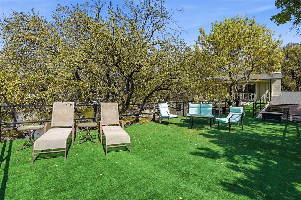 5014 Mohawk Court DeCordova, TX 76049 - Photo 28 of 36 a white bench sitting in the grass near a building