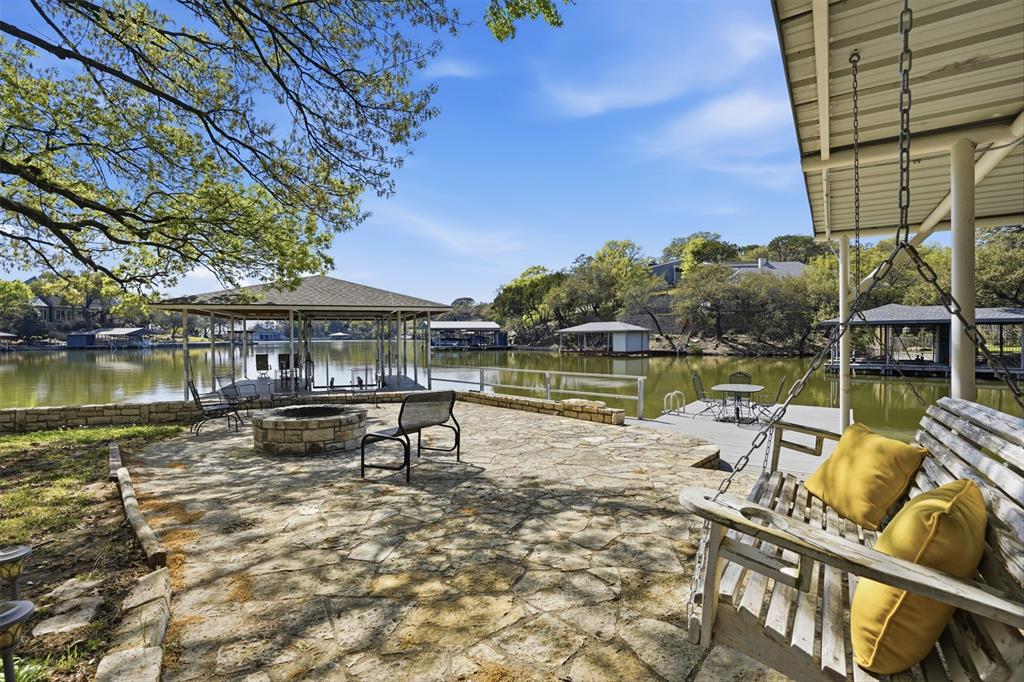 5014 Mohawk Court DeCordova, TX 76049 - Photo 31 of 36 a view of a lake with a bench next to a yard