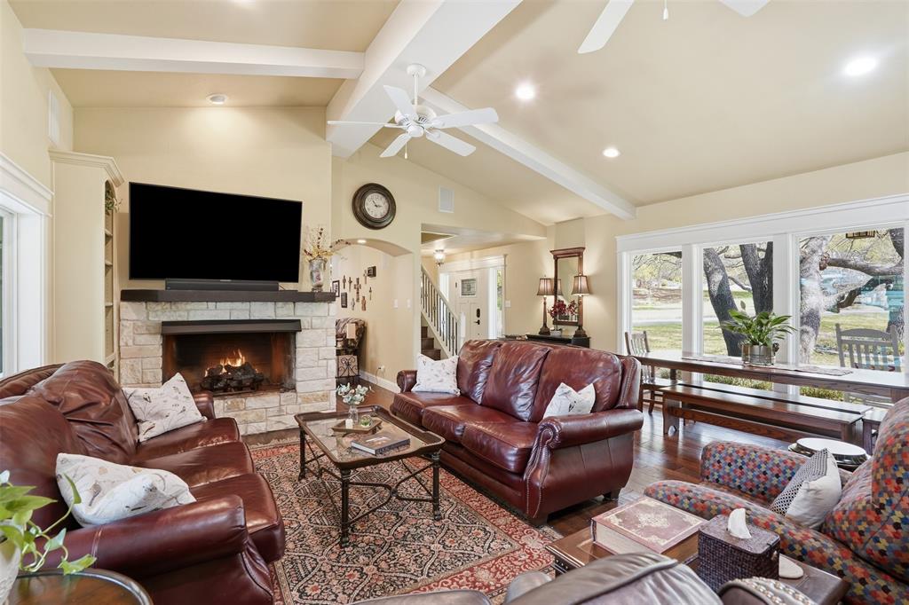 5014 Mohawk Court DeCordova, TX 76049 - Photo 6 of 36 a living room with furniture a flat screen tv and a fireplace