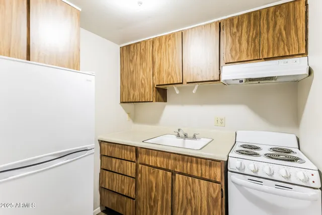 a kitchen with a refrigerator a stove a sink and a window