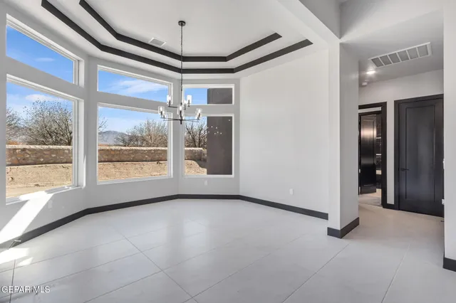 a view of an empty room with furniture and a window