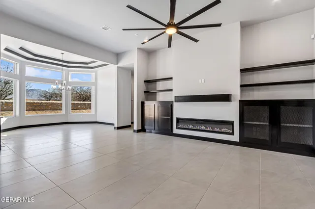 a living room with furniture a flat screen tv and a large window