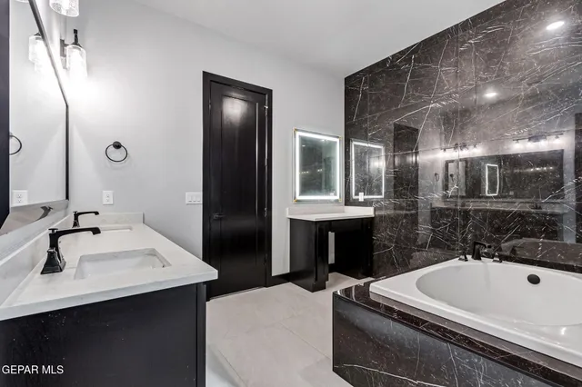 a large kitchen with a large counter top stainless steel appliances and cabinets