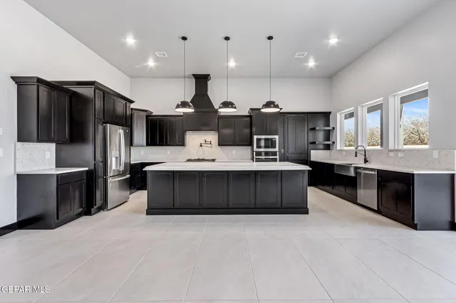 a large kitchen with stainless steel appliances a large center island and a sink