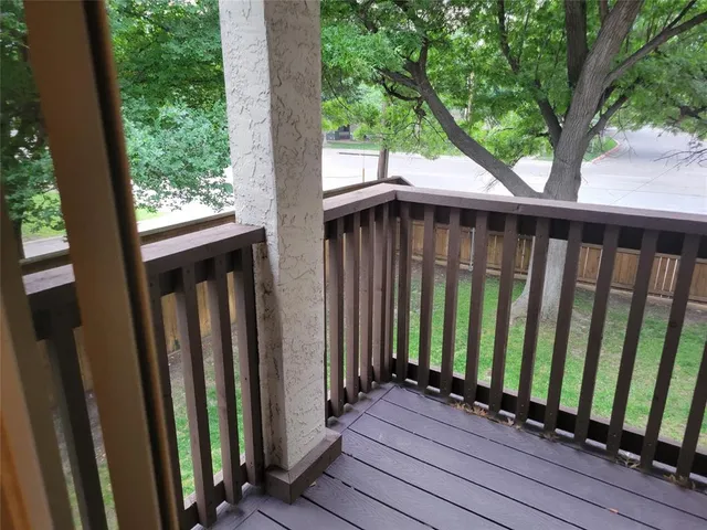 a view of balcony with wooden floor and fence