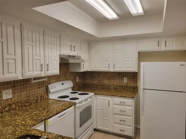 a kitchen with a sink a refrigerator and cabinets