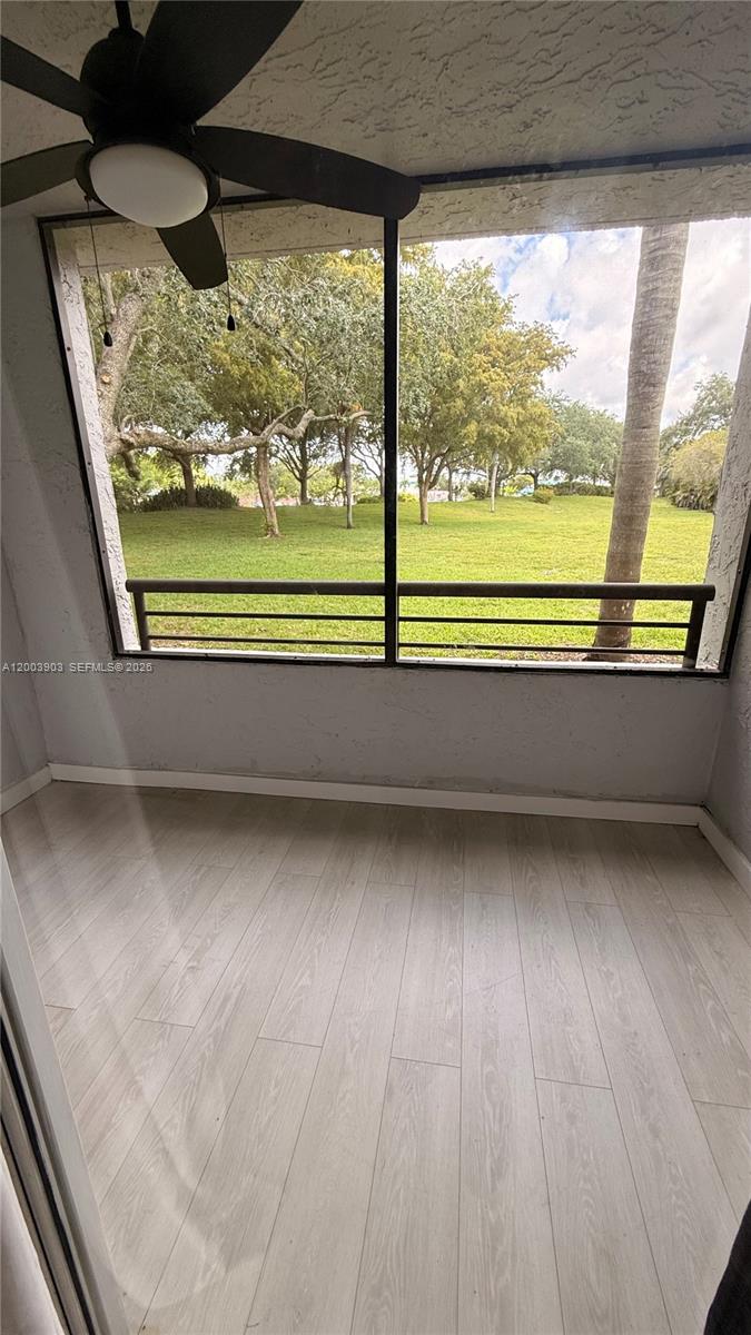 821 Lyons Road, Unit 21102 Coconut Creek, FL 33063 - Photo 2 of 17 a view of a room with wooden floor and a porch