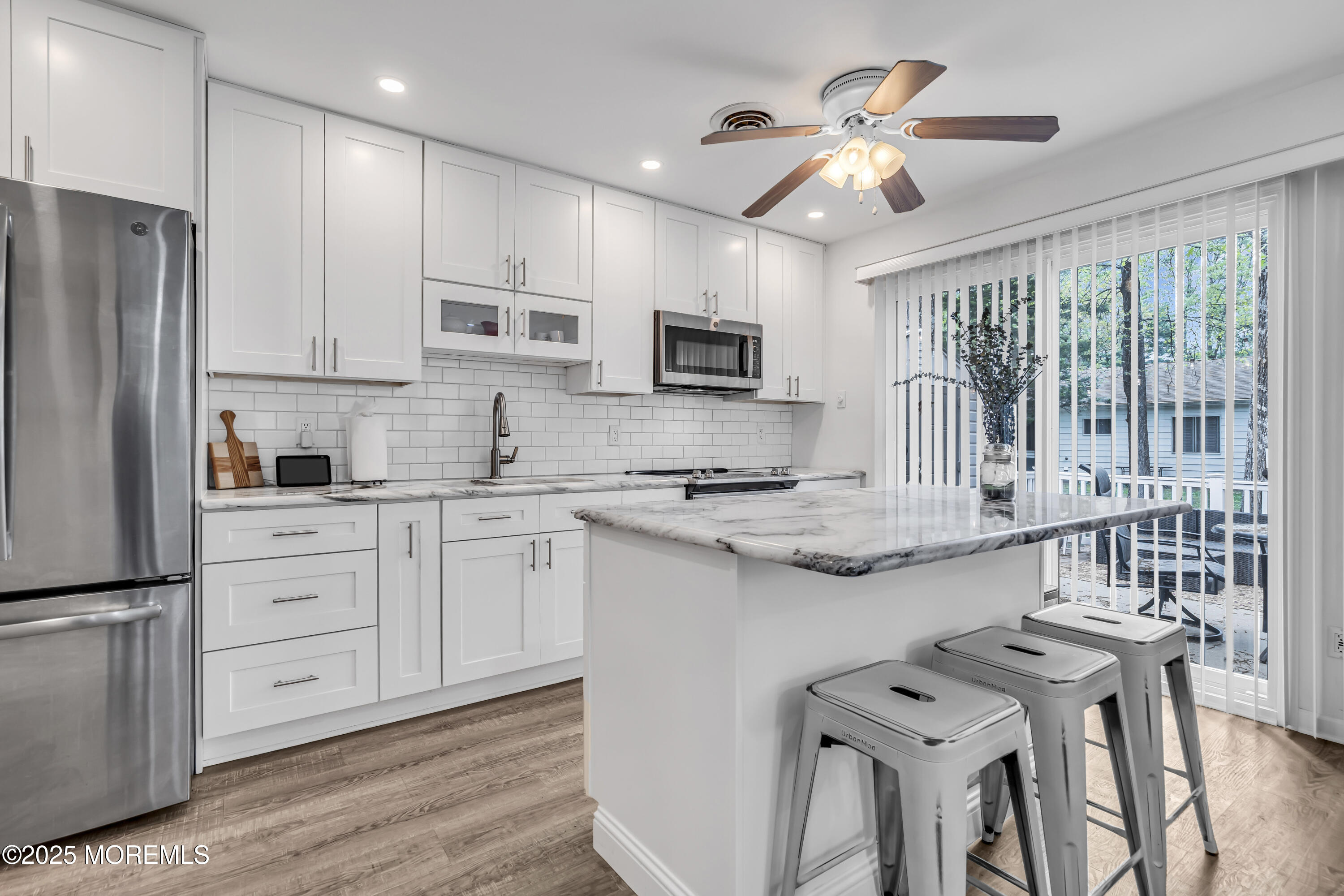 2 Oregon Drive, Unit A Whiting, NJ 08759 - Photo 8 of 26 a kitchen with stainless steel appliances granite countertop a stove top oven a refrigerator a sink and a dining table with wooden floor