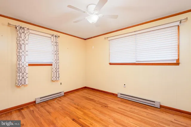 an empty room with a window and wooden floor