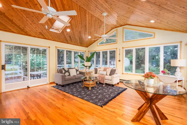 a living room with furniture a large window and chandelier