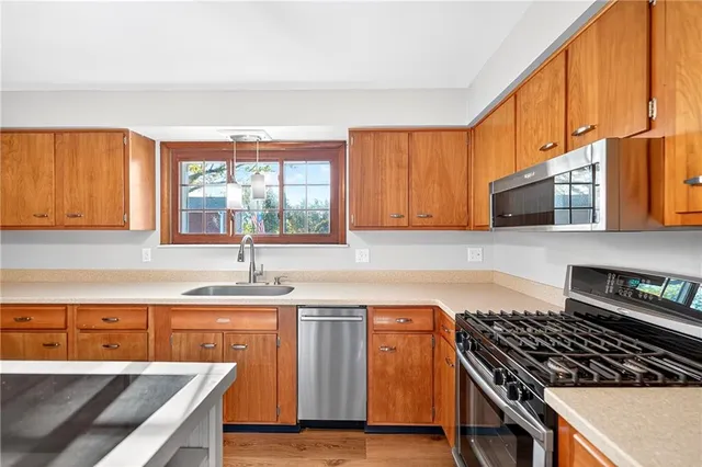 a kitchen with granite countertop a stove a sink and a microwave