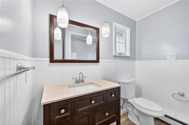 a bathroom with a toilet a sink and mirror