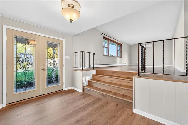 a view of entryway with wooden floor and front door