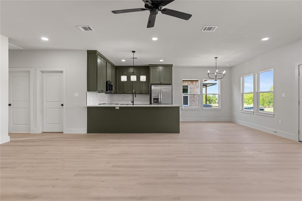 100 Arthur Avenue McGregor, TX 76657 - Photo 17 of 17 Kitchen with open floor plan, decorative backsplash, stainless steel appliances, light countertops, and recessed lighting