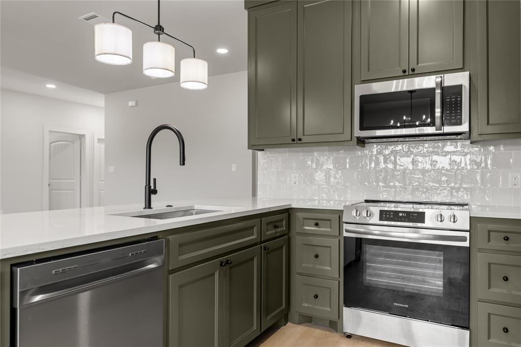 100 Arthur Avenue McGregor, TX 76657 - Photo 5 of 17 Kitchen featuring appliances with stainless steel finishes, light stone countertops, decorative backsplash, hanging light fixtures, and recessed lighting