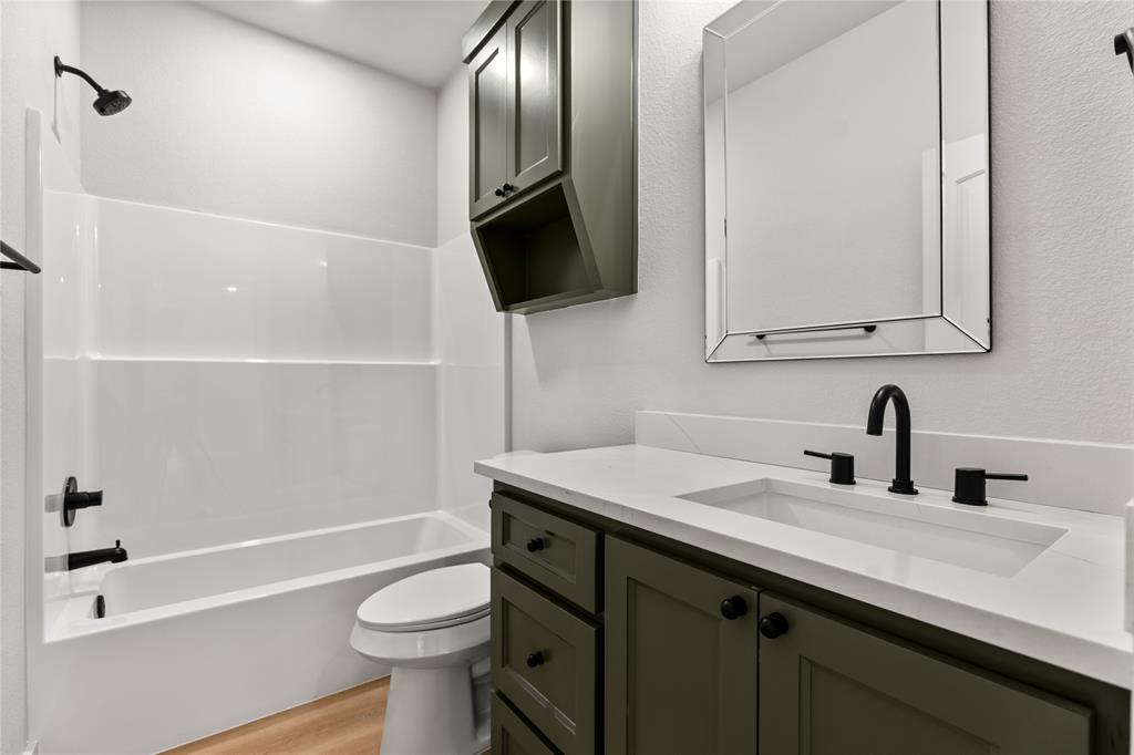 100 Arthur Avenue McGregor, TX 76657 - Photo 6 of 17 Bathroom with shower / tub combination, vanity, light wood finished floors, and a textured wall