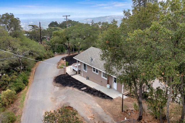 an aerial view of a house with a yard and mountain view in back