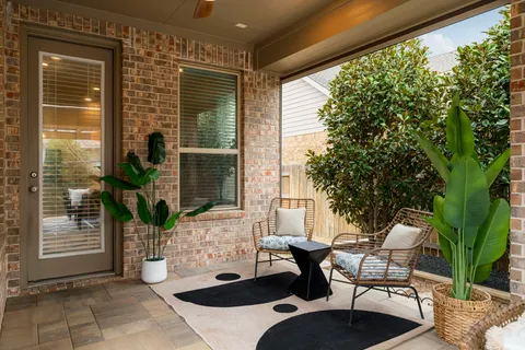 a view of a patio with couple of chairs and potted plants