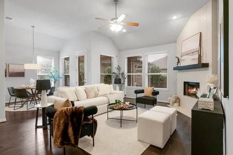 a living room with furniture fireplace and a large window
