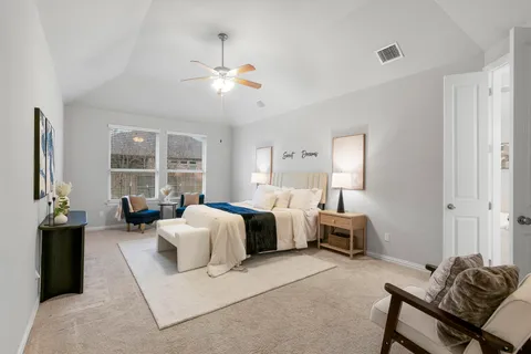 a spacious bedroom with a bed and ceiling fan