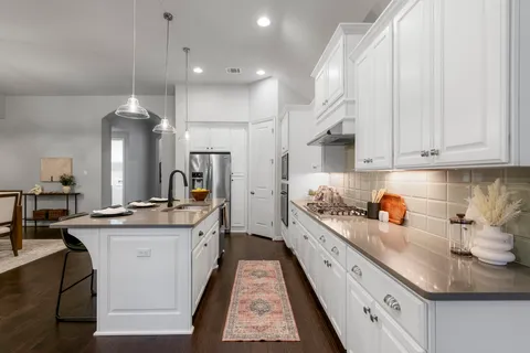 a kitchen with a sink stove and cabinets