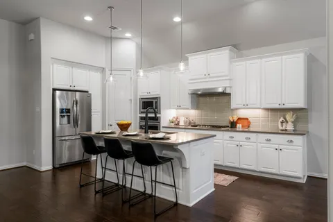 a kitchen with stainless steel appliances granite countertop a white cabinets and wooden floor